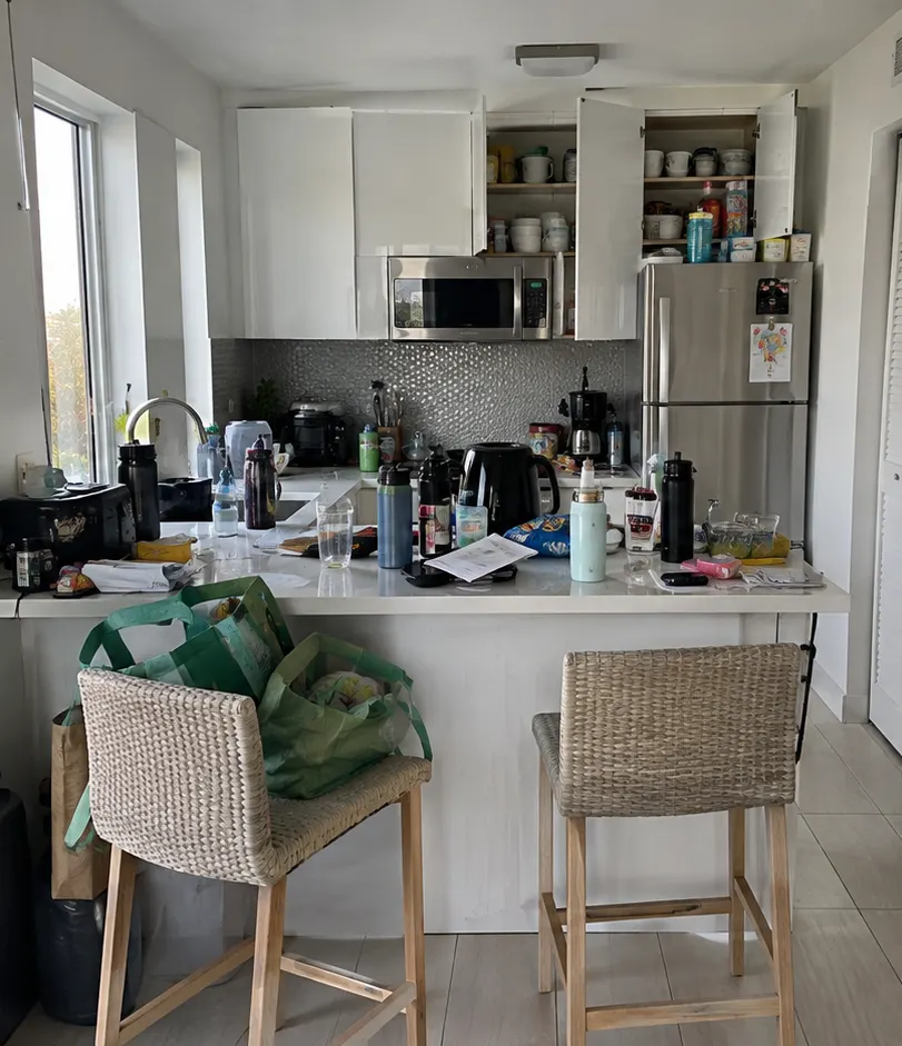 Small kitchen with cluttered counters before deep cleaning